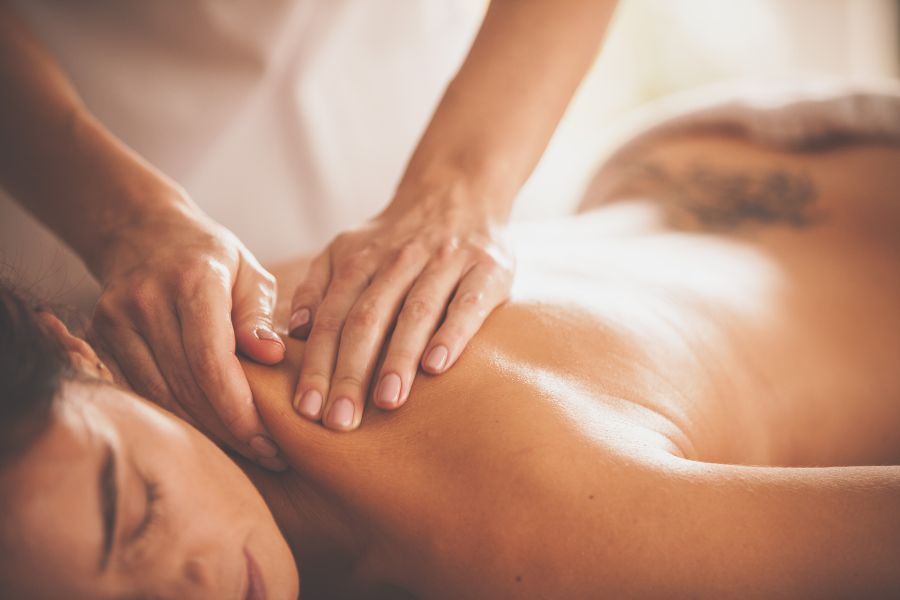 masajista realiza un masaje en la parte de la espalda y cervicales