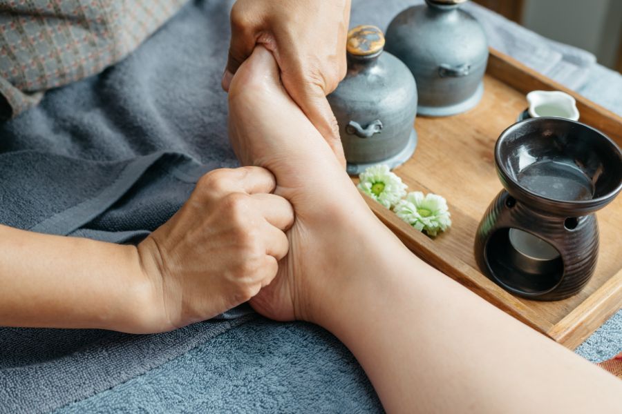 masaje con la mano haciendo presión en el pie
